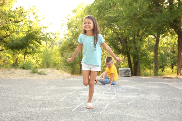 Schattige kleine kinderen die hinkelen, buiten