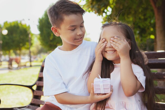 Schattige kleine kinderen genieten van warme zonnige dag in het park