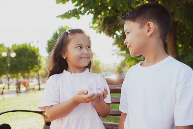 Schattige kleine kinderen genieten van warme zonnige dag in het park