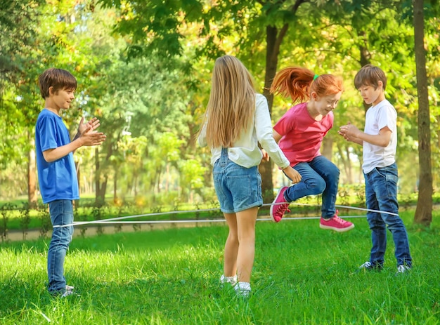 Schattige kleine kinderen springtouw in park