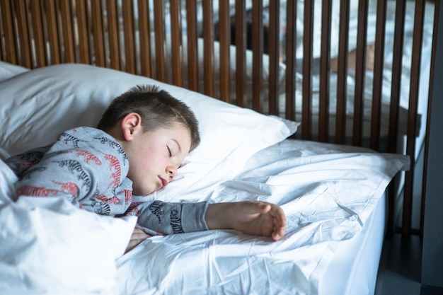 Schattige kleine kindjongen die in bed slaapt Lief peuterkind dat vredig thuis droomt