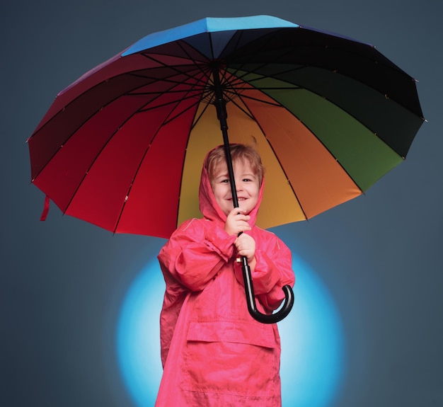 Schattige kleine kindjongen maakt zich klaar voor de herfst Kind heeft plezier met Leaf fall Cloud regenparaplu Raining concept Vrolijke jongen in regenjas met kleurrijke paraplu Raining kids