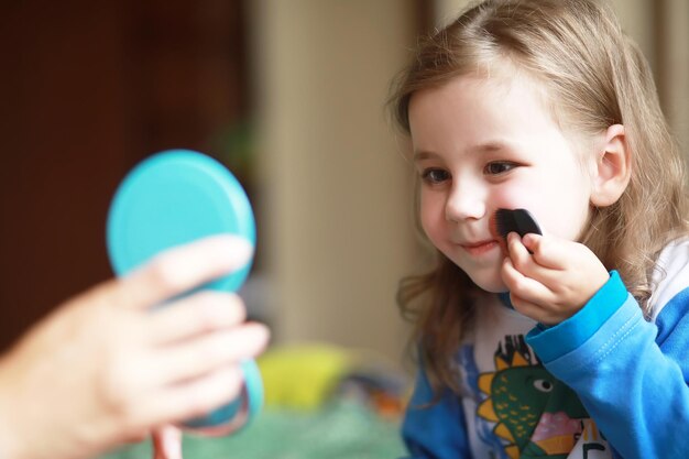 Schattige kleine meisjes die thuis met cosmetica spelen