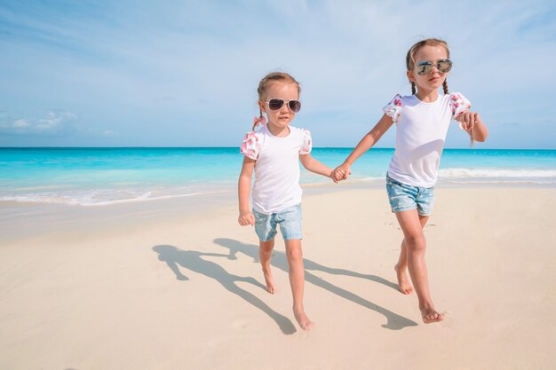 Schattige kleine meisjes hebben veel plezier op het strand.