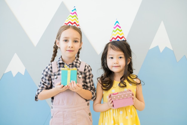 Schattige kleine meisjes in kleurrijke feestmutsen