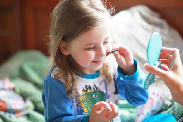 Schattige kleine meisjes spelen met cosmetica bij homexA