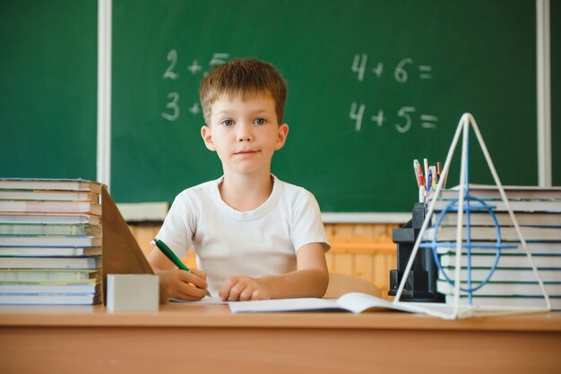 Schattige kleine schooljongen zitten in de klas