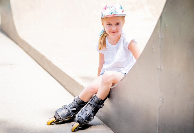 Schattige kleine vrouw op rolschaatsen in park