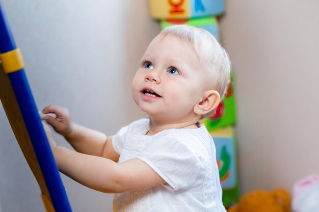 Schattige kleine vrouwelijke kunstenaar schildert op een ezel met krijt terwijl ze op een stoel staat