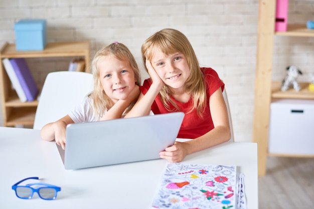 Schattige kleine zusjes poseren voor fotografie