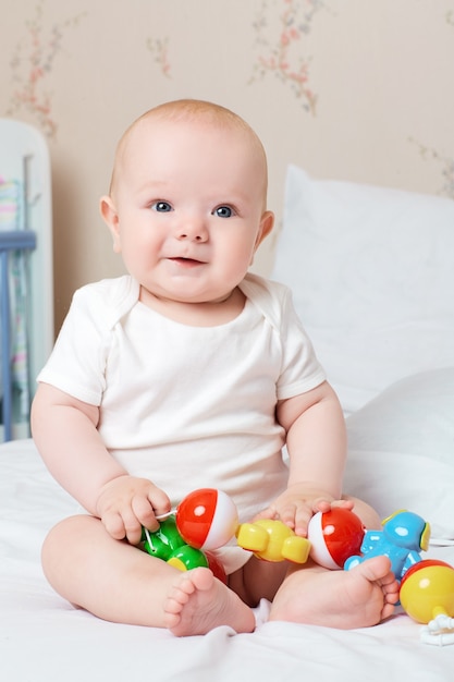 Foto schattige lachende baby lachen en glimlachen met een speeltje in zijn hand lach lach goed humeur speelgoed