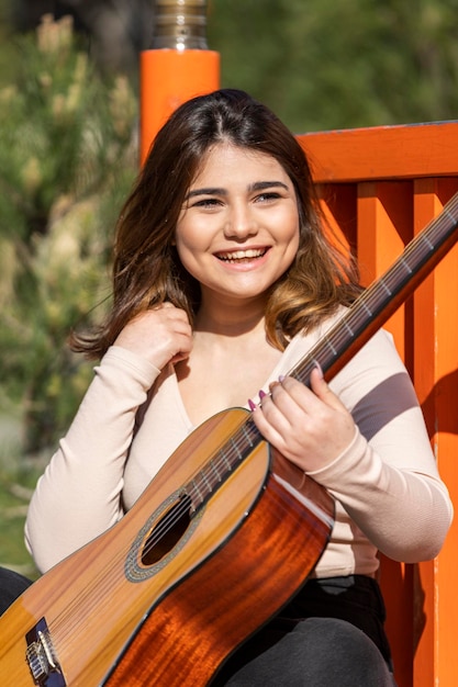 Schattige muzikant die gitaar speelt en lacht Foto van hoge kwaliteit