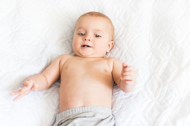 Foto schattige negen maanden oude baby glimlacht met zijn eerste tanden. kleine jongen rust