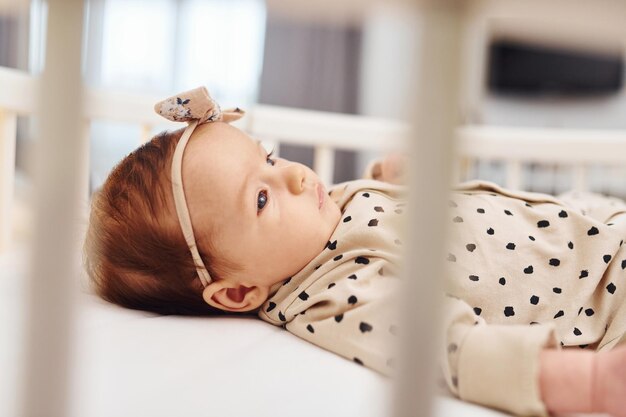 Schattige pasgeboren baby gaat overdag binnen in bed liggen