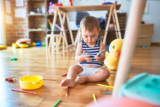 Schattige peuter die veel speelgoed speelt op de kleuterschool