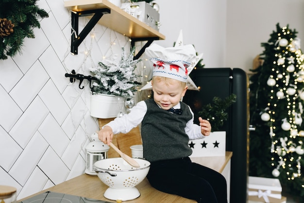 Schattige peuter zittend op een aanrecht in de keuken