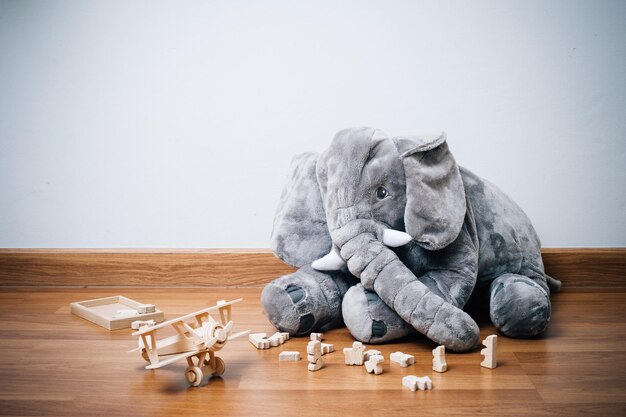 Schattige pluizige olifantenpop en houten speelgoed op de vloer