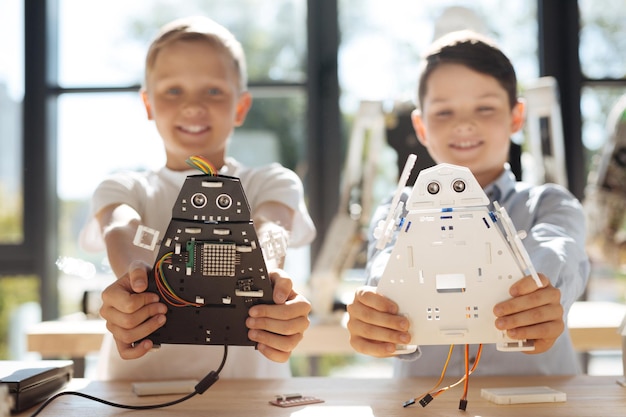 Schattige pre-tiener kinderen inspecteren werkplaats voor robotvoertuigen