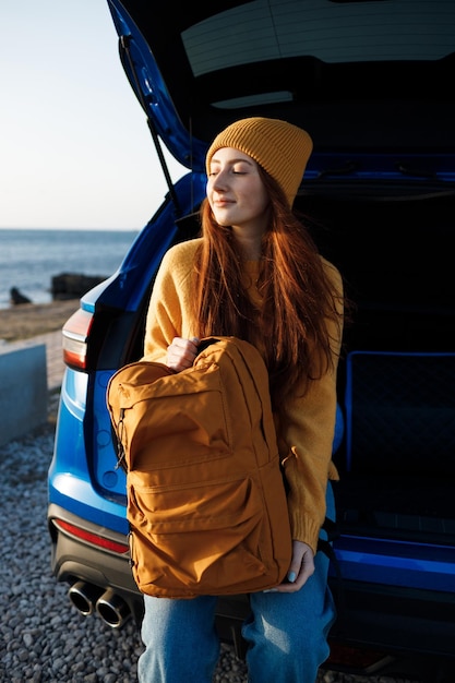 schattige roodharige vrouw gaat reizen met globe in auto