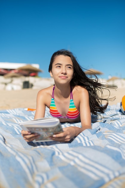 Schattige tienermeisje lezen op het strand