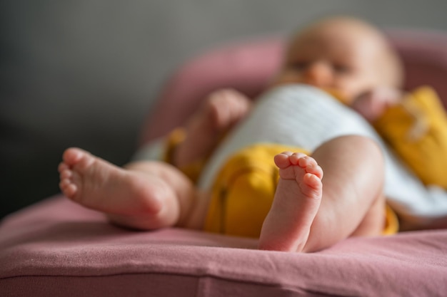 Schattige voetjes van een baby gekleed in een gele bodysuit