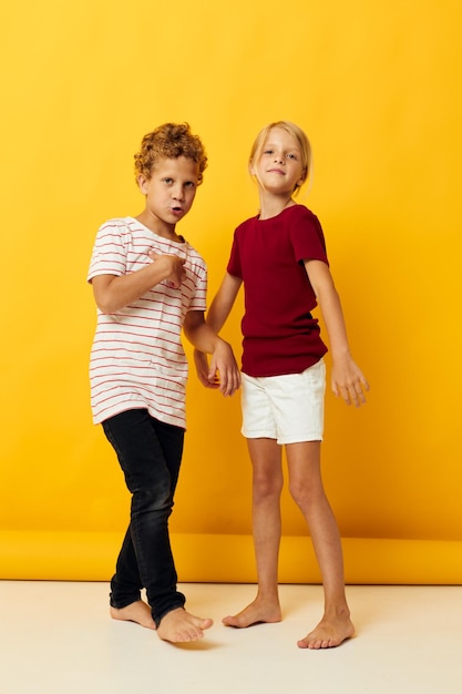 Schattige voorschoolse kinderen staan naast elkaar poseren jeugd emoties gele achtergrond
