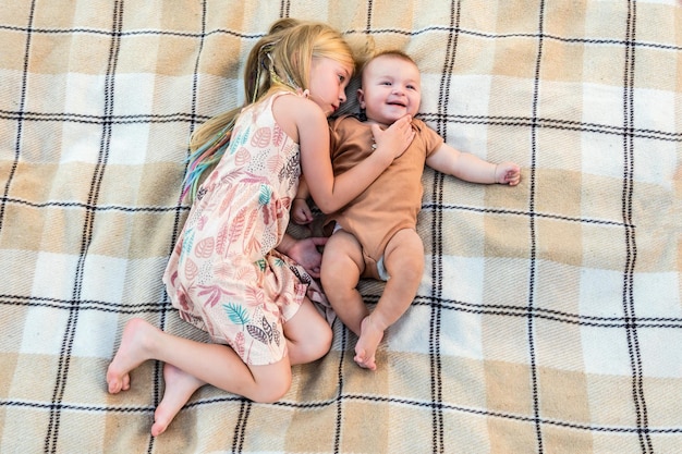 Schattige zus en kleine broer liggend op een deken in de zomer