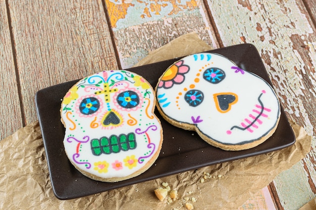 Schedelvormige boterkoekjes op een bruin bord (dia de los muertos).