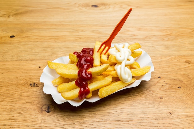 Schelp van frietjes met ketchup en mayonaise