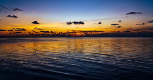 Foto schemering zonsonderganghemel boven zee in de avond op schemering met kleurrijk oranje zonlicht