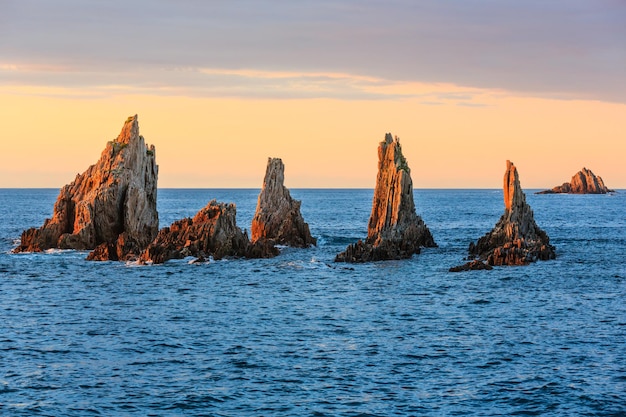 Scherpe eilandjes dichtbij Gueirua-strand (Asturias, Spanje). Avond landschap van de Atlantische Oceaan.