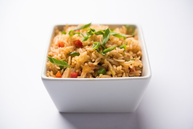 Schezwan Fried Rice Masala is a popular indo-chinese food served in a plate or bowl with chopsticks