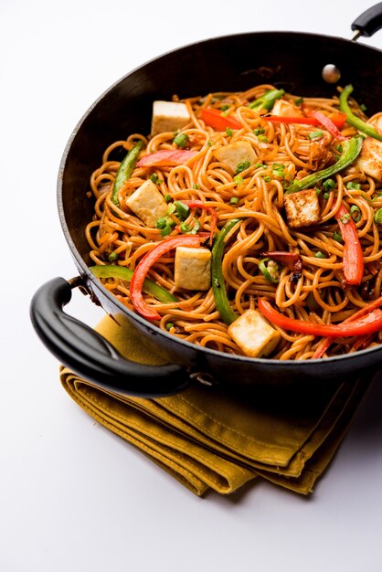 Schezwan hakka noodles with paneer or cottage cheese. Served in a bowl. selective focus