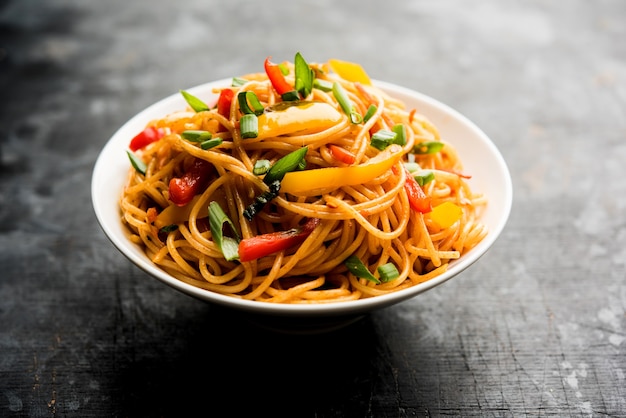 Schezwan Noodles of plantaardige Hakka Noodles of chow mein is een populair Indo-Chinees recept, geserveerd in een kom of bord met houten eetstokjes. selectieve focus