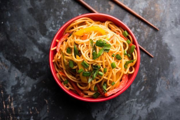 Schezwan Noodles of plantaardige Hakka Noodles of chow mein is een populair Indo-Chinees recept, geserveerd in een kom of bord met houten eetstokjes. selectieve focus