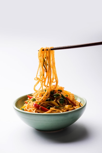 Schezwan Noodles of plantaardige Hakka Noodles of chow mein is een populair Indo-Chinees recept, geserveerd in een kom of bord met houten eetstokjes. selectieve focus