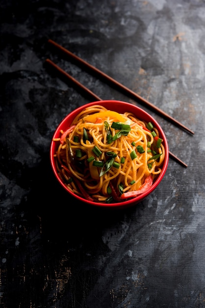 Schezwan Noodles of plantaardige Hakka Noodles of chow mein is een populair Indo-Chinees recept, geserveerd in een kom of bord met houten eetstokjes