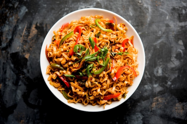 Schezwan vegetarische noedels is een pittige en smakelijke roergebakken platte Hakka noedels met saus en groenten. geserveerd met stokjes. selectieve focus