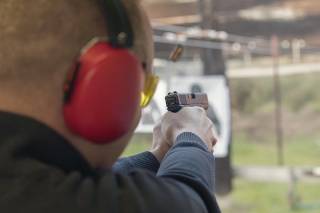 Schieten met een pistool. Man afvuren pistool in schietbaan.