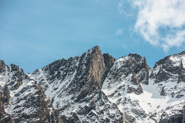 Schilderachtig alpenlandschap met besneeuwde bergtop op zonnige dag Geweldig landschap met rotsachtige top met sneeuw in zonlicht Prachtig uitzicht op de sneeuwbergtop en scherpe rotsen op zeer grote hoogte