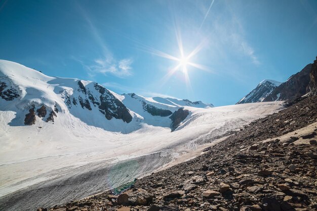 Schilderachtig berglandschap met grote gletsjer in zonlicht Geweldig landschap met glaciale tong onder zon in blauwe lucht Prachtig uitzicht op de Alpen op sneeuwbergtoppen op zeer grote hoogte in zonnige dag