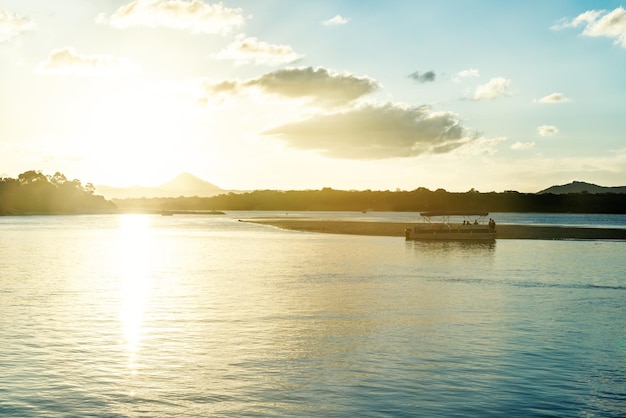 Schilderachtig uitzicht op de Noosa-rivier bij zonsondergang met een toerist in een bootTourist-conceptCopy Space