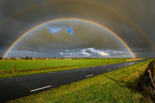 Foto schilderachtig uitzicht op de regenboog over het veld tegen de lucht