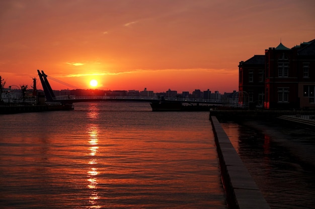 Schilderachtig uitzicht op de rivier tegen de oranje hemel bij zonsondergang