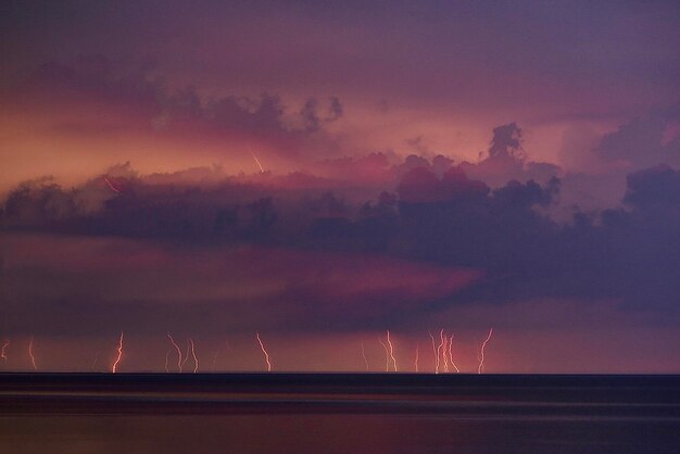 Foto schilderachtig uitzicht op de zee tijdens een onweersbui met veel bliksem in de verte