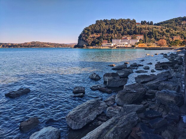 Schilderachtig uitzicht op geweldige rode zonsondergang aan de Adriatische Zee, kust. Slovenië. zomer. Visie. heuvels, olijfbomen