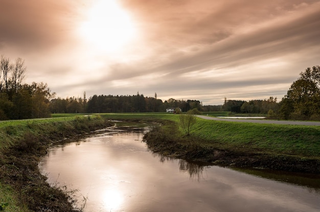 Schilderachtig uitzicht op het kanaal langs de weg tegen een bewolkte lucht