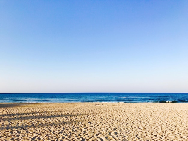 Schilderachtig uitzicht op het strand tegen een heldere blauwe lucht