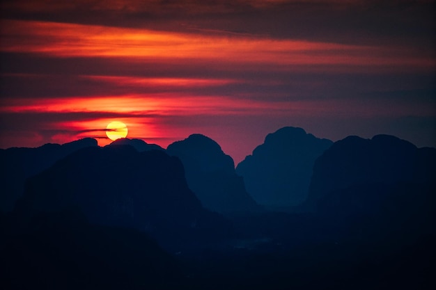 Schilderachtig uitzicht op silhouetten van bergen tegen een oranje hemel