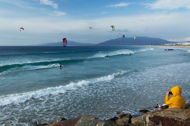 Schilderachtig uitzicht op windsurfers op zee tegen een bewolkte hemel